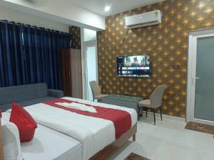 a bedroom with a bed and a tv on a wall at Hotel SS Residency in Patna +12 photos