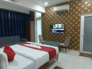 a bedroom with a bed and a tv on a wall at Hotel SS Residency in Patna