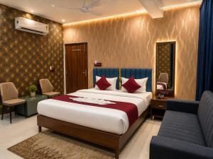 a hotel room with a bed and a couch and a bed and a chair at Hotel SS Residency in Patna