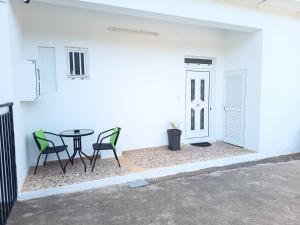 a patio with a table and chairs next to a white wall at Veranda with Endless View among Orange Trees in Fournés