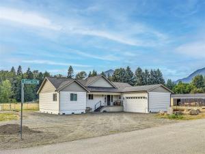 a house with a garage on the side of a road at Airport Place: 4 bedrooms, AC, Grill in Packwood