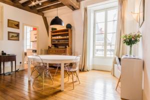 une salle à manger avec une table et des chaises blanches dans l'établissement Les Bons Enfants, à Dijon