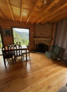 a living room with a table and chairs and a fireplace at El Quetzalito Cabin in San Gerardo de Dota +21 photos