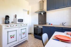a kitchen with blue cabinets and a table with a plate on it at Valras'Loc - Evasion Marine in Valras-Plage