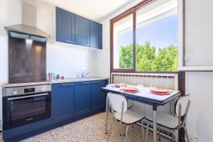 a kitchen with blue cabinets and a table with chairs at Valras'Loc - Evasion Marine in Valras-Plage