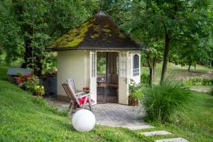 a small shed with a grass roof with a chair at Landhouse Bled - Adults Only in Bled +202 photos