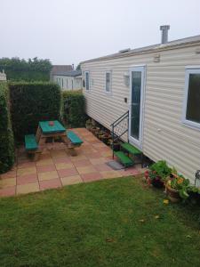 an rv with a table and a picnic table at 16 Vale Park in Fishguard +6 photos