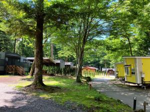 a row of mobile homes in a park with trees at PICA Fujiyoshida in Fujiyoshida +174 photos