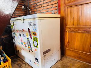 a refrigerator covered in magnets and stickers in a room at Lakey Views Sumbawa in Huu