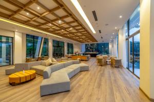 a large living room with couches and tables and windows at Haven in the Pines in Da Lat