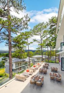 an outdoor patio with tables and chairs and trees at Haven in the Pines in Da Lat