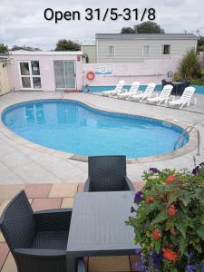 a large swimming pool with chairs and a table at 16 Vale Park in Fishguard