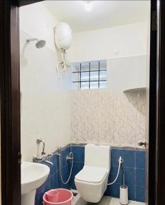 a bathroom with a toilet and a sink at Electrifying Pearl in Bangalore