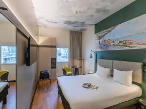 a hotel room with a bed with a white bedspread at Hotel Ibis Lisboa Parque das Nações in Lisbon