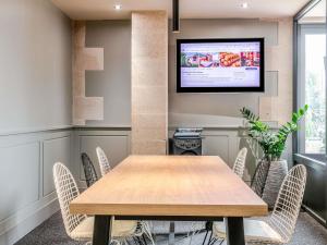 a conference room with a wooden table and chairs at ibis Bordeaux Saint Emilion in Saint-Émilion