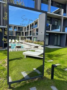 a mirror on the grass in front of a building at Infinutum Sea Studio in Palanga +6 photos
