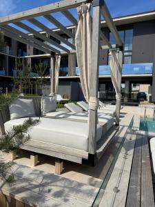 a bed on a patio with a canopy at Infinutum Sea Studio in Palanga