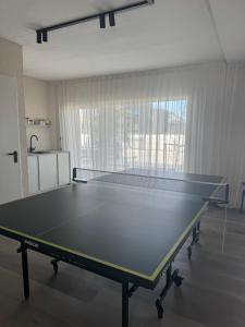 a ping pong table in the middle of a room at Infinutum Sea Studio in Palanga