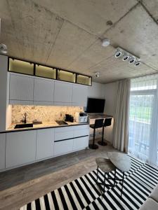 a kitchen with white cabinets and a table and chairs at Infinutum Sea Studio in Palanga
