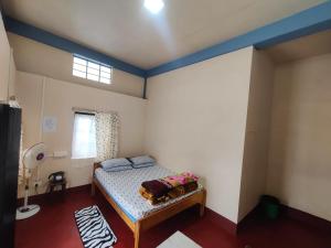 a bedroom with a bed in a room with a window at K J Homestay in Cherrapunji