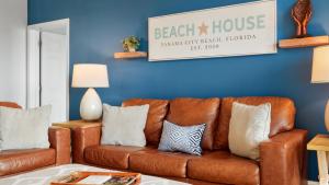 a brown leather couch in a living room with a blue wall at Laketown Wharf 809 in Panama City Beach