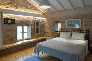 a bedroom with a bed and two windows at Olive Press 1816 in Riglia +19 photos