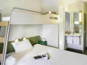 a room with a bed with a camera on it at Ibis budget München Airport Erding in Erding +52 photos