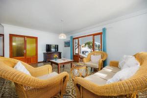 a living room with wicker chairs and a couch at Apartamentos MHM in Cala Ratjada