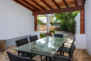 a patio with a glass table and chairs at Apartamentos MHM in Cala Ratjada