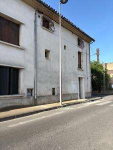 ein weißes Gebäude an einer Straßenseite in der Unterkunft Suite Maison Roche in Carpentras