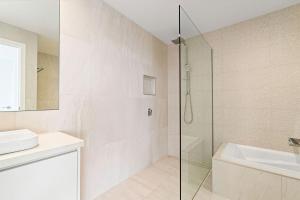 a bathroom with a glass shower and a sink at Gums & Ocean Hideaway at Wye in Wye River