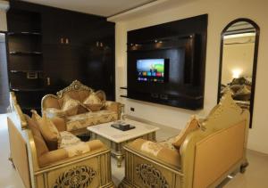 a living room with chairs and a flat screen tv at Hotel Capital in Noida +17 photos