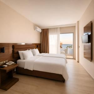 a hotel room with a large bed and a window at Ozgur Bey Spa Hotel in Alanya