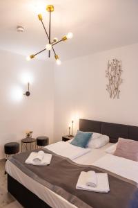 two beds in a bedroom with two stools at Oportó Panzió in Villány