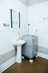 a white bathroom with a sink and a toilet at Aisya homestay jerteh in Jertih +33 photos