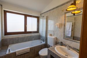 a bathroom with a tub and a toilet and a sink at Oportó Panzió in Villány +9 photos