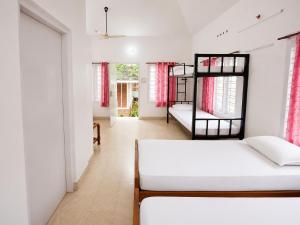 a bedroom with two bunk beds and a hallway at K Cottage in Varkala