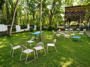 a group of chairs and tables in the grass at K Cottage in Varkala