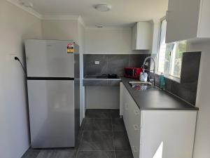 a small kitchen with a refrigerator and a sink at Sansa Farmhouse in Kelmscott +19 photos