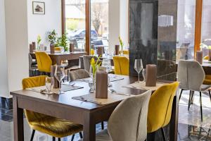 a dining room with tables and yellow chairs at Oportó Panzió in Villány