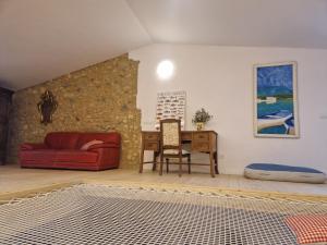 ein Wohnzimmer mit einem roten Sofa und einem Tisch in der Unterkunft Ca la Babus in Bellcaire dʼEmpordà