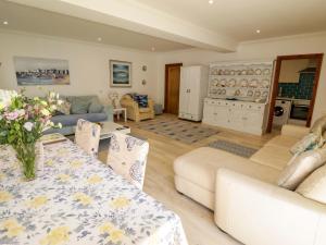 a living room with a table and a couch at Charlecote House in Saundersfoot
