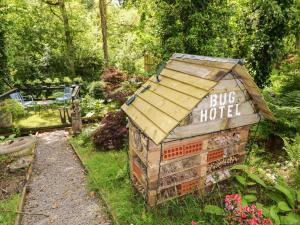 a small brick building with a sign for a bug hotel at Charlecote House in Saundersfoot