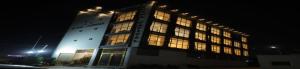 a large building with lit up windows at night at Hotel Capital in Noida