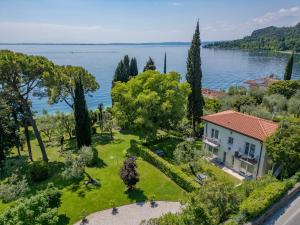 an aerial view of a house on the shore of a lake at Appartamenti Villa Andrea in Garda