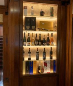 a cabinet filled with lots of bottles of wine at Resort Dei Limoni Tower Inn in Lucca
