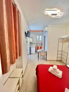 a room with a red bed and a kitchen at Studio Osnao Historic City Center in Cefalù