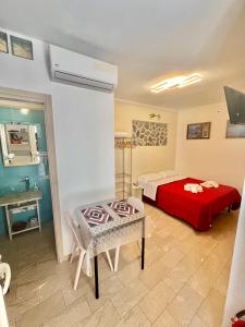 a bedroom with a bed and a table in a room at Studio Osnao Historic City Center in Cefalù
