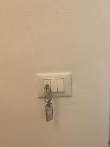 a key hanging from a lightswitch on a wall at Studio Osnao Historic City Center in Cefalù