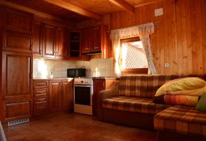 a kitchen with wooden cabinets and a couch in a room at Apartments Gatej in Cerkno